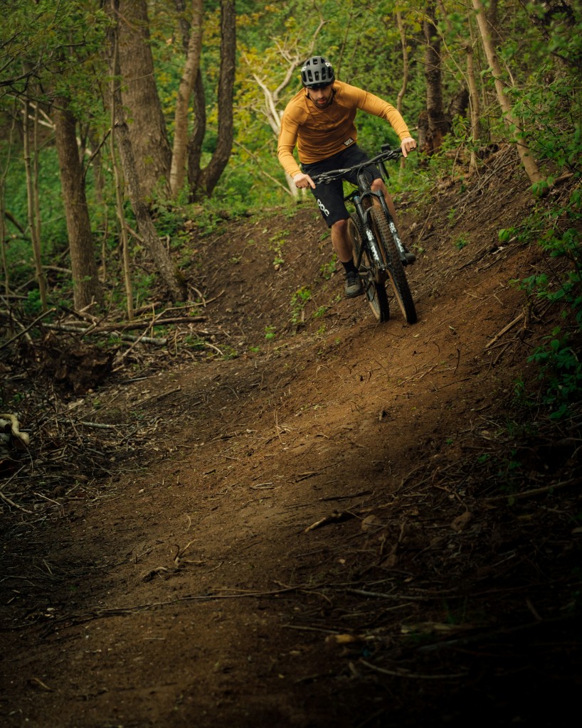 Mountain biker riding a berm on a forest trail